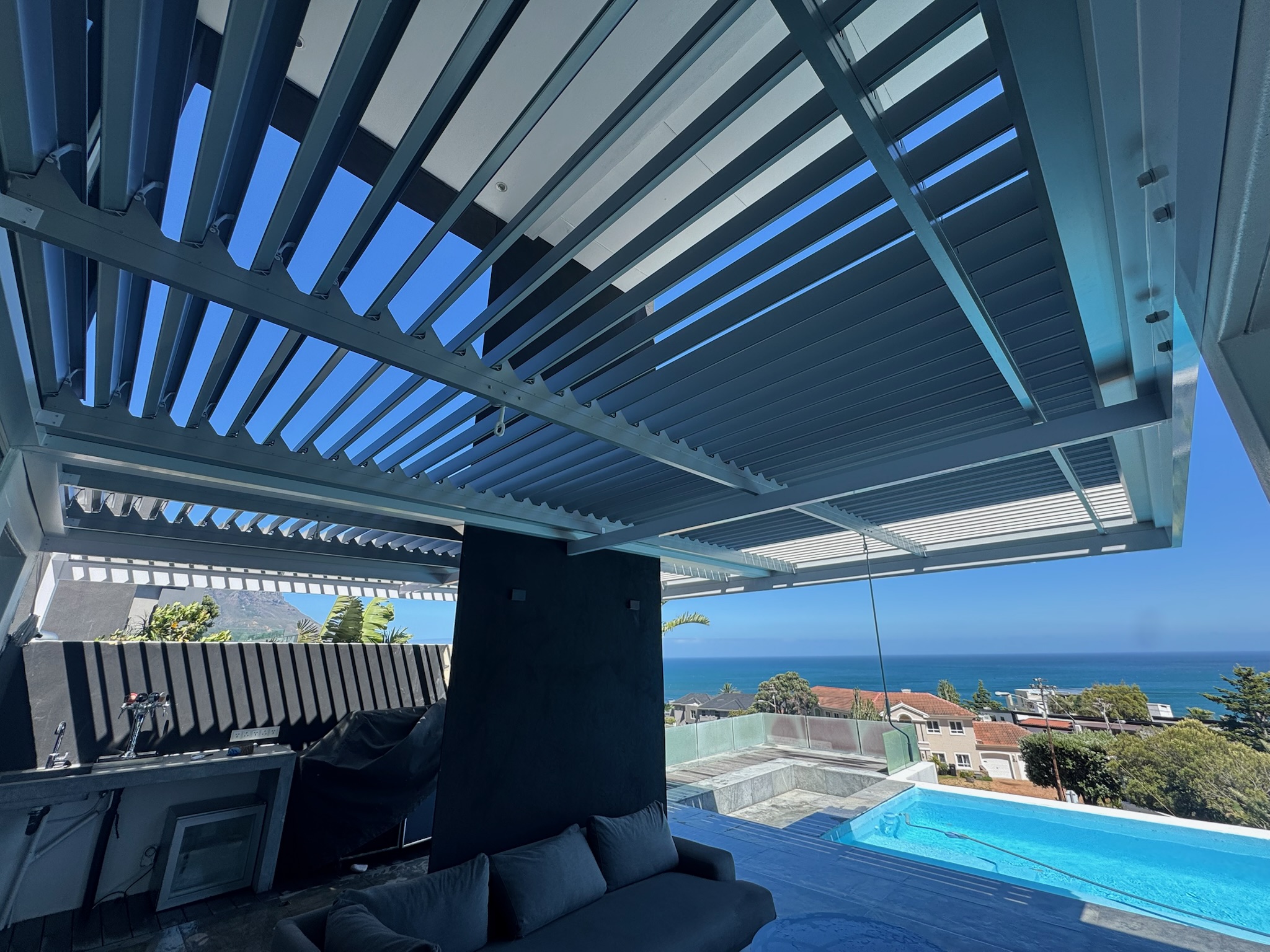 Grey powder-coated louvre awning providing sun control on a Durbanville veranda.