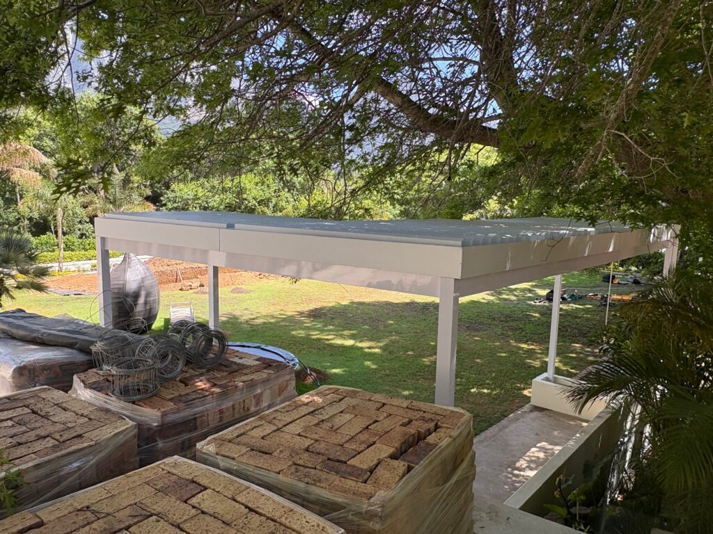 Multi-bank adjustable louvre awning covering a large outdoor entertainment area.